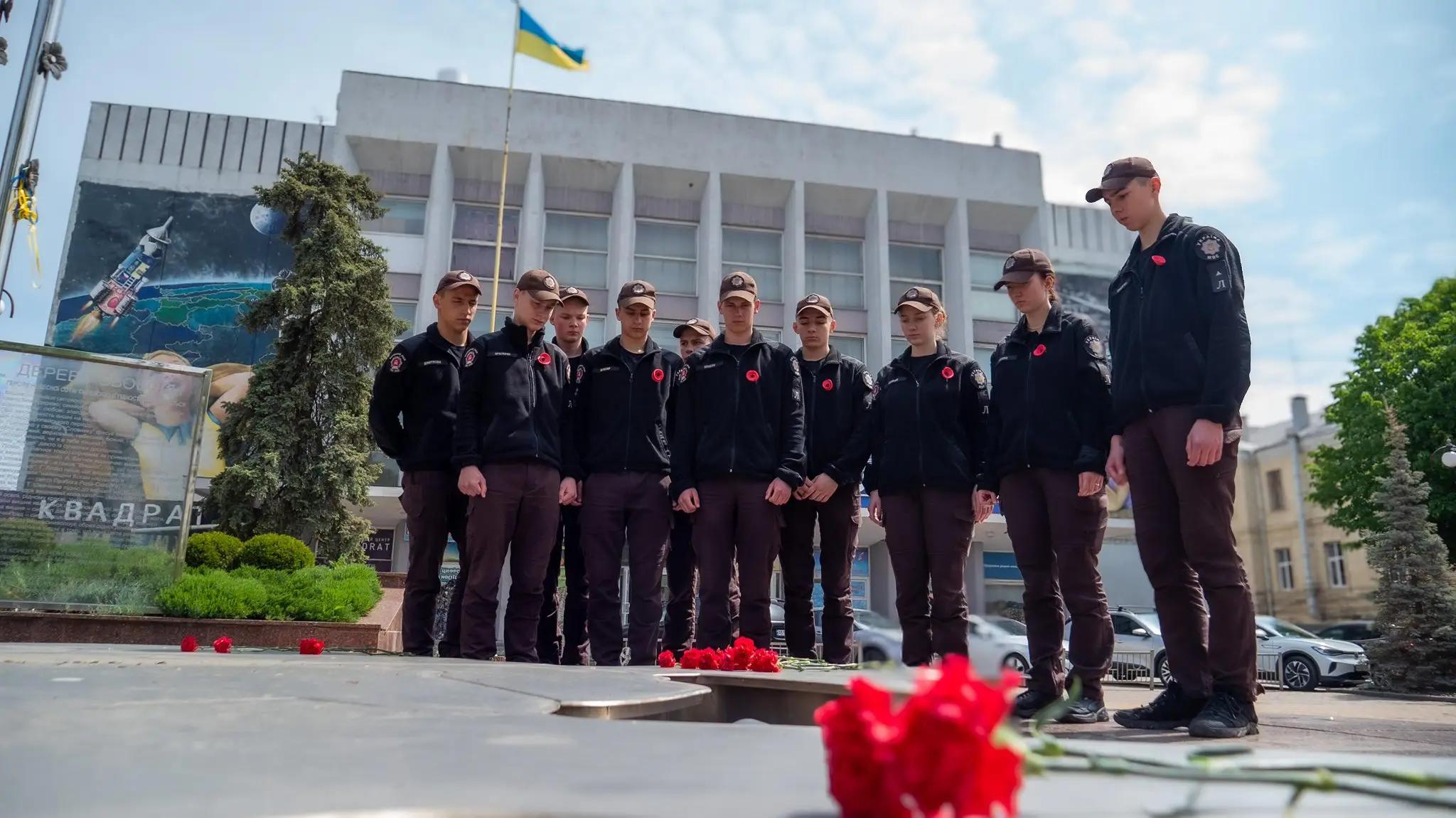 Ліцеїсти покладають квіти до «Дерева свободи» та тримають червоні маки — символ пам’яті про жертв війни